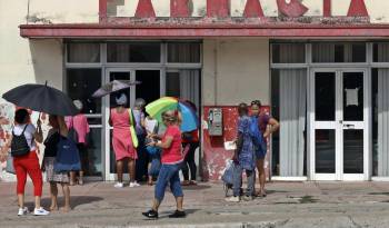Personas esperan afuera de una farmacia, el 19 de enero de 2024, en La Habana (Cuba). EFE/ Ernesto Mastrascusa