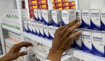 Un hombre coloca medicamentos en una clínica recién inaugurada para pacientes con VIH/SIDA en Cali, Colombia.