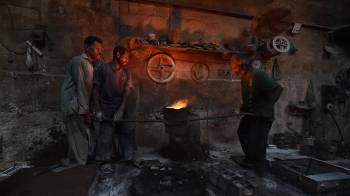 Obreros trabajan en una fábrica en vísperas del Día Internacional de los Trabajadores.