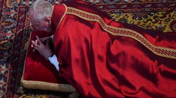 Foto de la Semana Santa de 2017 en la que el papa Francisco se postra ante el altar en la ceremonia de la Pasión de Cristo del Viernes Santo en la basílica de San Pedro del Vaticano.