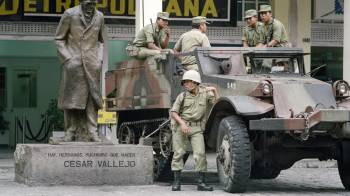 Soldados custodian la entrada de un banco, el 10 de abril de 1992, cerca de la estatua del poeta peruano César Vallejo