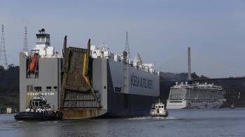 Fotografía de un buque de carga de transporte de automóviles junto a un crucero transitan, el 7 de diciembre del 2023, por la ruta del canal de Panamá (Panamá).