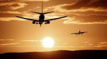 Imagen ilustrativa de aviones y un atardecer.
