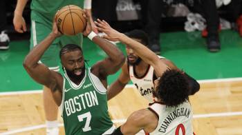 El escolta de Boston Celtics, Jaylen Brown (izq.), resiste con el balón a la presión del escolta de Detroit Pistons, Cade Cunningham.