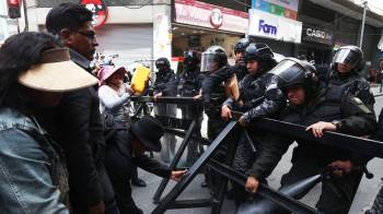 Integrantes de la policía de Bolivia y manifestantes se enfrentan durante una protesta este lunes en La Paz.