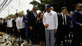 El alcalde de Nueva York, Eric Adams (C), sostiene una flor roja mientras camina frente al club nocturno Jet Set en Santo Domingo el 14 de abril de 2025.