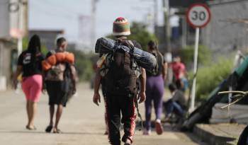 Migrantes caminan por una calle en la subregión de Urabá, en el municipio de Turbo.