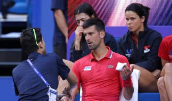 Novak Djokovic recibe atención médica en un momento de su partido contra el australiano Alex de Minaur.