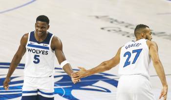 Anthony Edwards (i) choca su mano con Rudy Gobert (d) de los Minnesota Timberwolves.