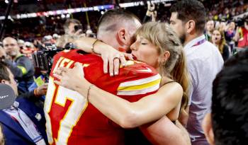 El jugador de los Kansas City Chiefs, Travis Kelce (i) abraza a su novia, la cantante Taylor Swift (d).