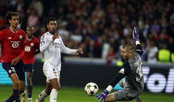 El portero francés del Lille Lucas Chevalier (d) detiene un disparo del inglés del Real Madrid, Jude Bellingham.