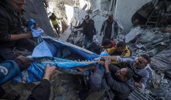 Palestinos recuperan un cuerpo entre los escombros de una casa destruida tras los ataques aéreos israelíes, en Deir Al Balah, en el centro de la Franja de Gaza. Foto de archivo.