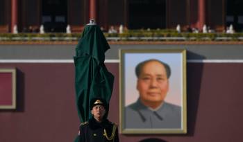 Un soldado del Ejército Popular de Liberación de China (EPL) hace guardia frente a un retrato del difunto líder comunista Mao Zedong exhibido frente a la Puerta de Tiananmen en Beijing.