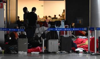 Pasajeros de India y Vietnam esperan mientras permanecen varados en el Aeropuerto Internacional de Guarulhos en Sao Paulo, Brasil.