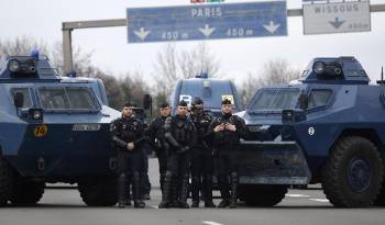 Miembros de la policía francesa y vehículos antidisbrubios en un acceso a París.