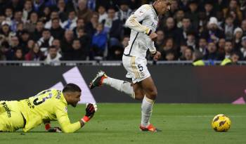 El centrocampista del Real Madrid, Jude Bellingham (d), se lleva el balón ante el guardameta argentino del Girona, Paulo Gazzaniga, durante el encuentro correspondiente a la jornada 24 de primera división que disputan Real Madrid y Girona en el estadio Santiago Bernabéu, en Madrid.