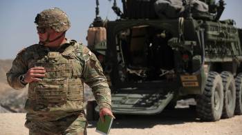Un integrante del Ejército de Estados Unidos camina junto a un vehículo blindado 'Stryker' este domingo, en la frontera con Ciudad Juárez Chihuahua (México).