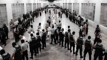 Fotografía cedida el pasado 15 de marzo por la Presidencia de El Salvador en la que se registró a cientos de guardias del Centro de Confinamiento del Terrorismo (Cecot) al ingresar a decenas de ciudadanos venezolanos, deportados desde EE.UU. y acusados de presuntamente pertenecer a la Organización criminal transnacional Tren de Aragua, a esta cárcel en Tecoluca (El Salvador).