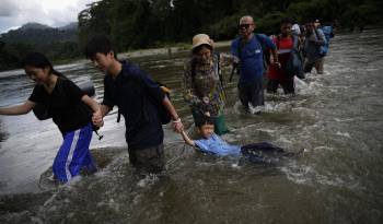 Migrantes cruzan el río Turquesa en Darién, en una fotografía de archivo.