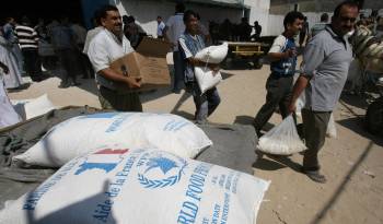 Palestinos cargan sacos de alimentos que recibieron de la Agencia de Obras Públicas y Socorro de las Naciones Unidas (UNRWA) en el campo de refugiados de al-Shati en la ciudad de Gaza el 17 de septiembre de 2008