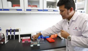 Personal del laboratorio explica a los medios un método de análisis de muestra de agua.