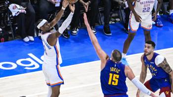 El escolta de los Oklahoma City Thunder, Shai Gilgeous-Alexander (izq.) lanza a canasta ante el pívot de los Denver Nuggets Nikola Jokic.
