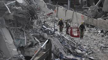 Miembros de la unidad israelí de búsqueda y rescate inspeccionan el sitio del colapso de un edificio en construcción en Bangkok.