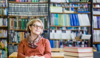 Happy relaxing or dreaming senior woman in library