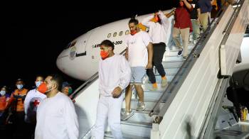 Fotografía cedida por Prensa del Ministerio de Interior, Justicia y Paz, donde se observa a migrantes bajar de un avión este viernes, en el Aeropuerto Internacional Simón Bolívar, en La Guaira (Venezuela)