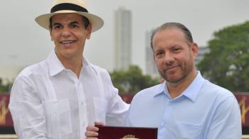 Carlos de Oliveria Jr. (I) entrega la placa de reconocimiento al Dr. Monty Motta.