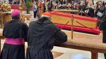 El monseñor José Domingo Ulloa Mendieta y el cardenal José Luis Lacunza Maestrojuán rezan de rodillas frente al atud del papa Francisco.