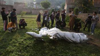 La gente se encuentra de pie cerca de la parte dañada de un avión no identificado en un complejo de la mezquita en Pampore, en las afueras de Srinagar, India, el 07 de mayo de 2025.
