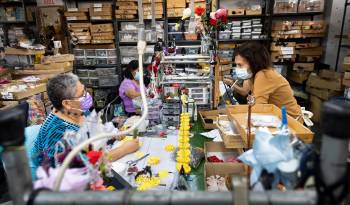 Empleados de M &amp; S Schmalberg trabajan en el montaje de flores artificiales individuales en la fábrica de la empresa en el Garment District de Nueva York.