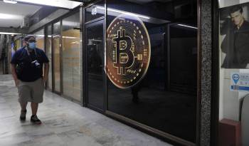 Un hombre camina frente a una tienda de criptomonedas el en la zona bancaria de Buenos Aires, en una fotografía de archivo.