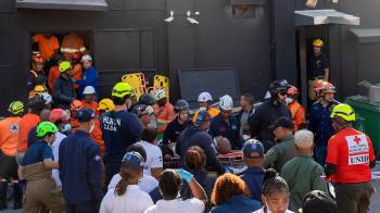 Integrantes del cuerpo de bomberos y de rescate evacúan a un herido este martes, en la discoteca Jet Set en Santo Domingo (República Dominicana). EFE/ Orlando Barría