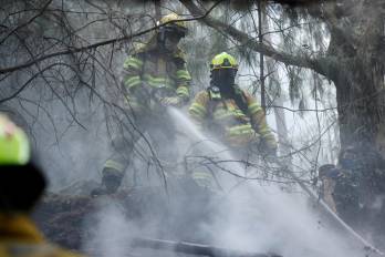Bomberos trabajan en la extinción de un incendio, en el cerro El Cable, en Bogotá.