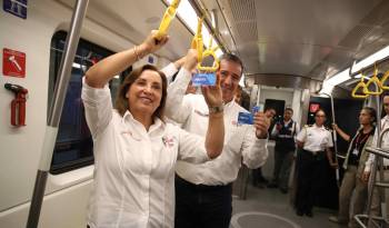 La presidenta del Perú, Dina Boluarte (i), y el ministro peruano de Transportes y Comunicaciones, Raúl Pérez Reyes (d), muestran las tarjetas del Metro durante su primer recorrido hoy, en Lima (Perú).