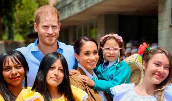 Los duques de Sussex, el príncipe Harry (c-i) y Meghan (c-d), posando junto a niños en el Colegio La Giralda, en Bogotá, Colombia.
