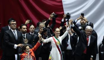 La presidenta de México Claudia Sheinbaum (centro) acompañada del mandatario saliente, Andrés Manuel López Obrador (2018-2024), saludan al termino de la toma de posesión en la Cámara de Diputados este martes en la Ciudad de México.