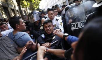 Manifestantes chocan con policías en las afueras del Congreso hoy, en Ciudad de Guatemala (Guatemala).
