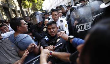 Manifestantes chocan con policías en las afueras del Congreso hoy, en Ciudad de Guatemala (Guatemala).