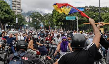 Opositores al gobierno de Nicolás Maduro recorren las calles en motocicletas este lunes, en Caracas.