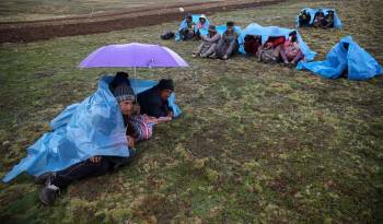 Campesinos descansan bajo la lluvia durante la faena de volteo de la tierra de cultivo, en San José de Apata, provincia de Jauja (Perú).