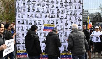 Un cartel muestra fotografías de presos políticos en Venezuela durante la manifestación de opositores políticos venezolanos que ha tenido lugar este domingo en Madrid.