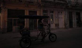 Fotografía de archivo del 26 de marzo de 2024 de un bicitaxi que transita por una calle oscura debido a un apagón, en La Habana, Cuba.