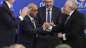 El secretario general saliente de la OEA, el uruguayo Luis Almagro (d), felicita al surinamés Albert Ramdin (i) por su elección como nuevo secretario general de la organización.