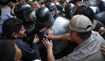 Manifestantes chocan con policías en las afueras del Congreso hoy, en Ciudad de Guatemala (Guatemala). Algunos diputados han denunciado trabas en la instalación del nuevo congreso, que debe realizarse este domingo para poder, después, dar paso a la investidura del presidente electo, Bernardo Arévalo de León.