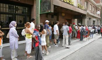 Foto de archivo de un numeroso grupo de inmigrantes guardando fila ante una oficina de la Seguridad Social en Madrid.
