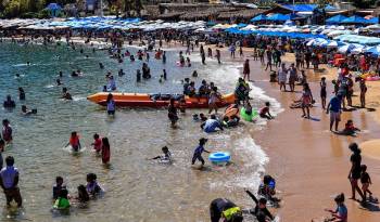 Turistas disfrutan en una playa, el 29 de marzo de 2024 en el balneario de Acapulco, México