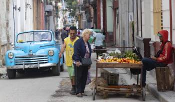 Una mujer observa verduras en un puesto ambulante, este 20 de diciembre de 2023,, en La Habana (Cuba). EFE/ Yander Zamora